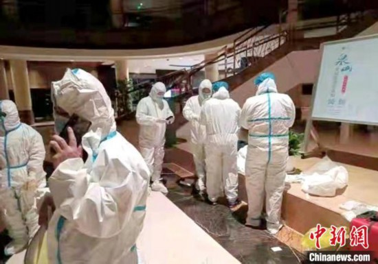 11月25日夜，在开元宾馆隔离点，民警穿着防护服争分夺秒地准备进行流调溯源核查工作。　徐州警方供图