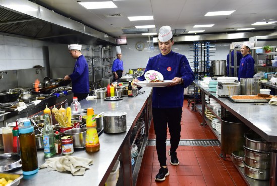 5月3日，在工作的酒店，刘旭峰准备为客人端上装饰着自已的果酱画的菜肴。